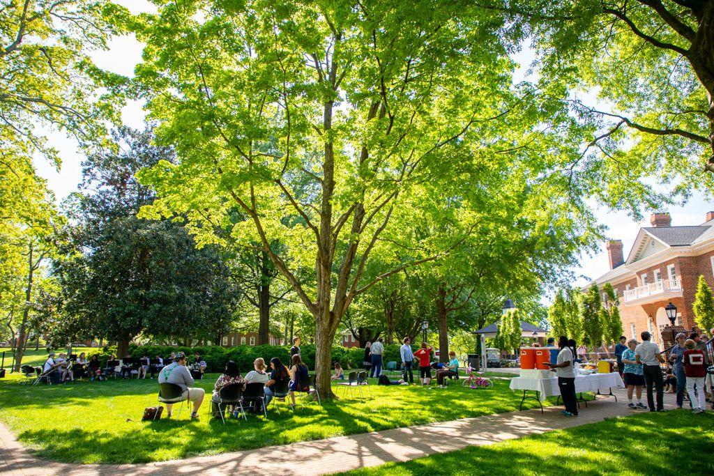 Students and community members gathered under the canopy at a campus event.